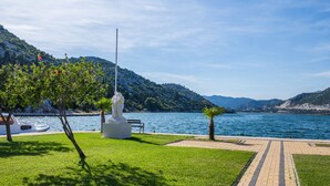 A park with a statue, a boat, and a lake.