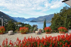 A scenic outdoor area with a lake view, potted plants, and a stone bench. - Agriturismo Il Colle (Bellagio)