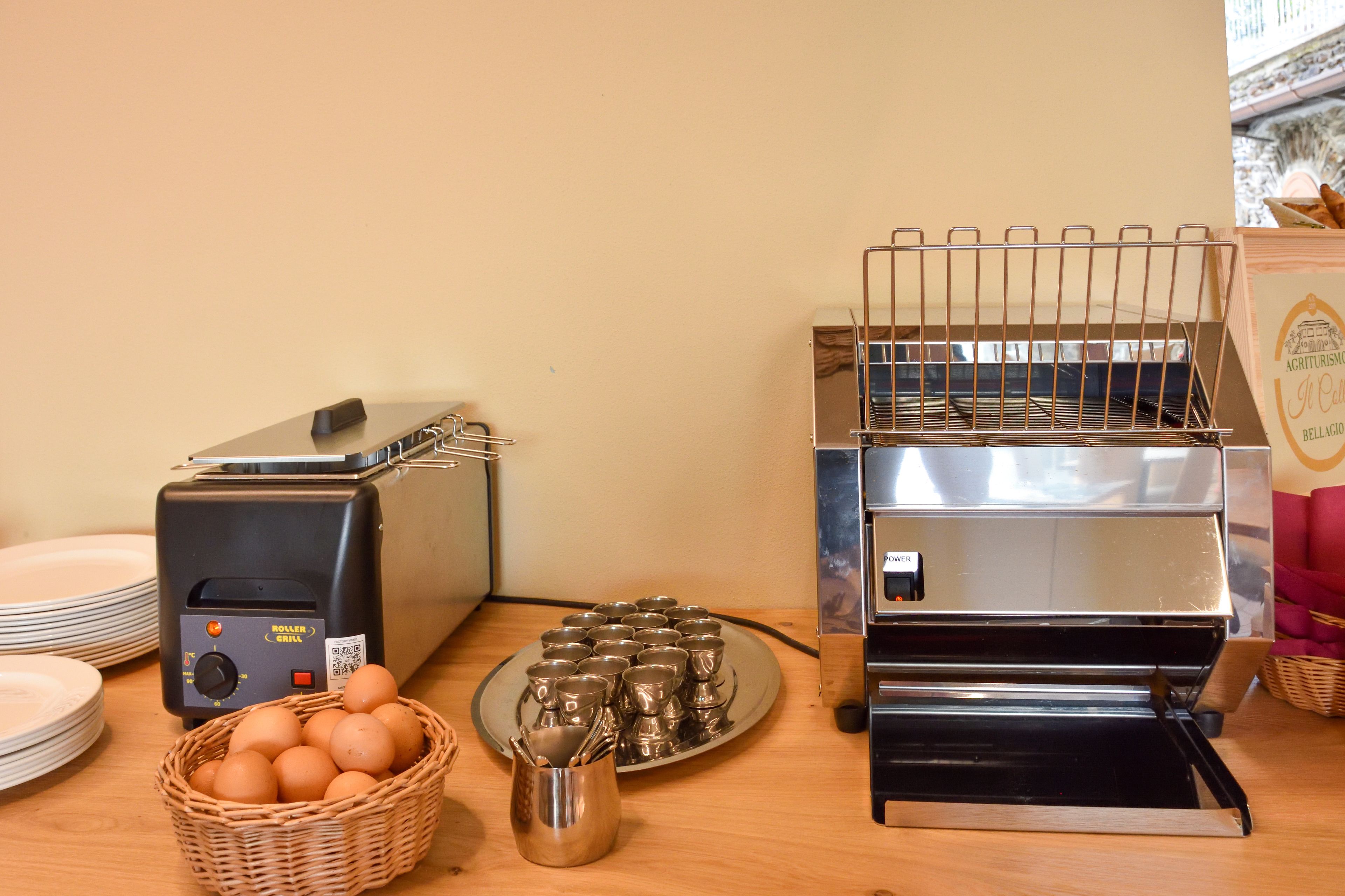 Un plateau de petit-déjeuner comprenant un grille-pain, une machine à café et une assiette d’œufs.