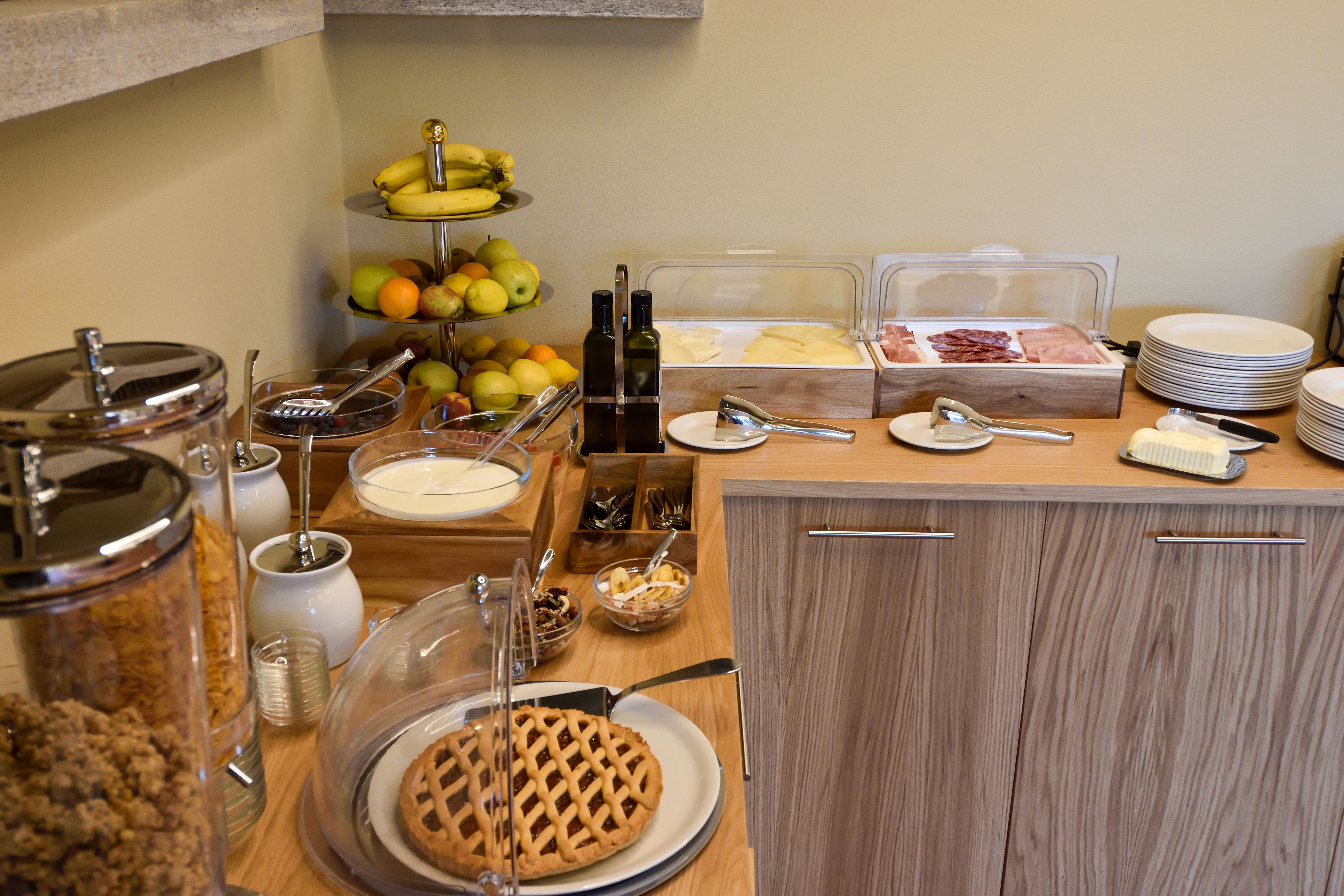 A breakfast buffet with various food items and utensils.