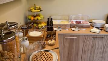 A breakfast buffet with various food items and utensils.