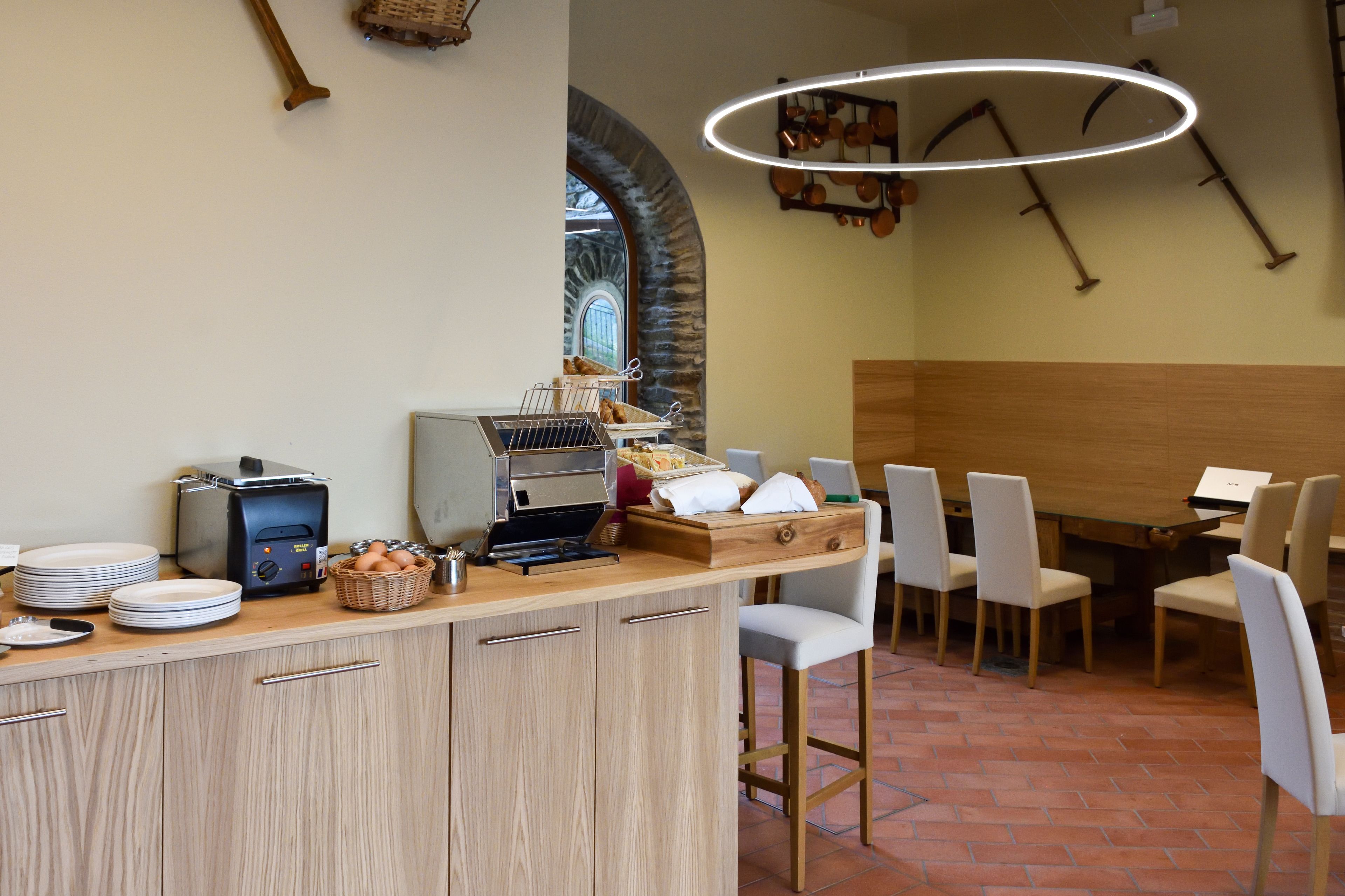 A breakfast bar with a toaster, plates, and a basket of eggs. There are chairs and a table in the dining area.