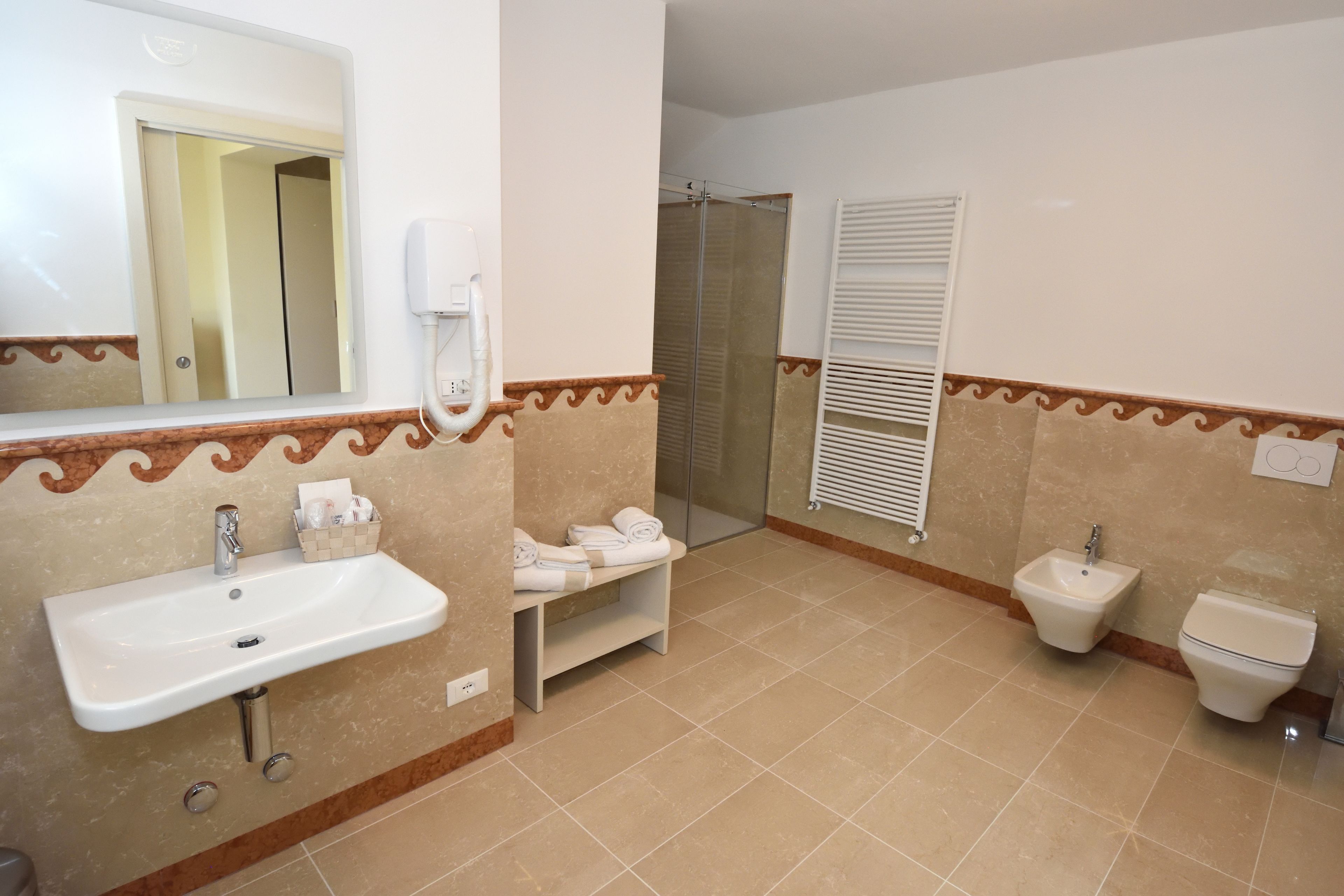 Une salle de bain équipée d’un lavabo, d’un bidet, de toilettes et d’un espace douche.