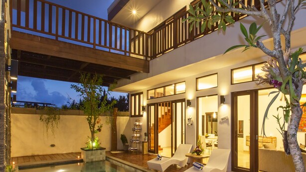 Ein moderner Poolbereich mit klarem Pool, Liegestühlen und einer Treppe zu einer erhöhten Ebene.