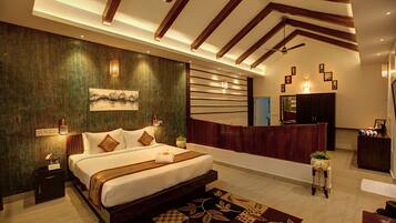 A modern hotel room with a large bed, a reception desk, and a small balcony.