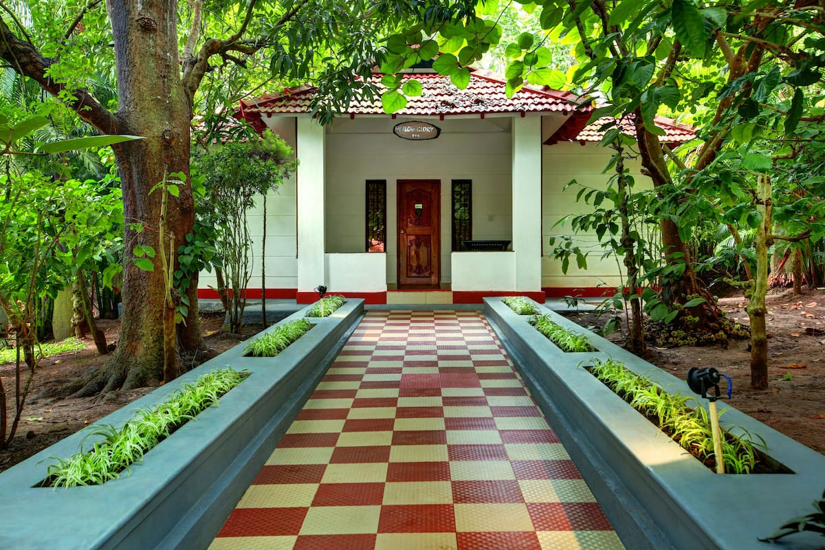 Um edifício com chão quadriculado, rodeado por árvores e plantas.