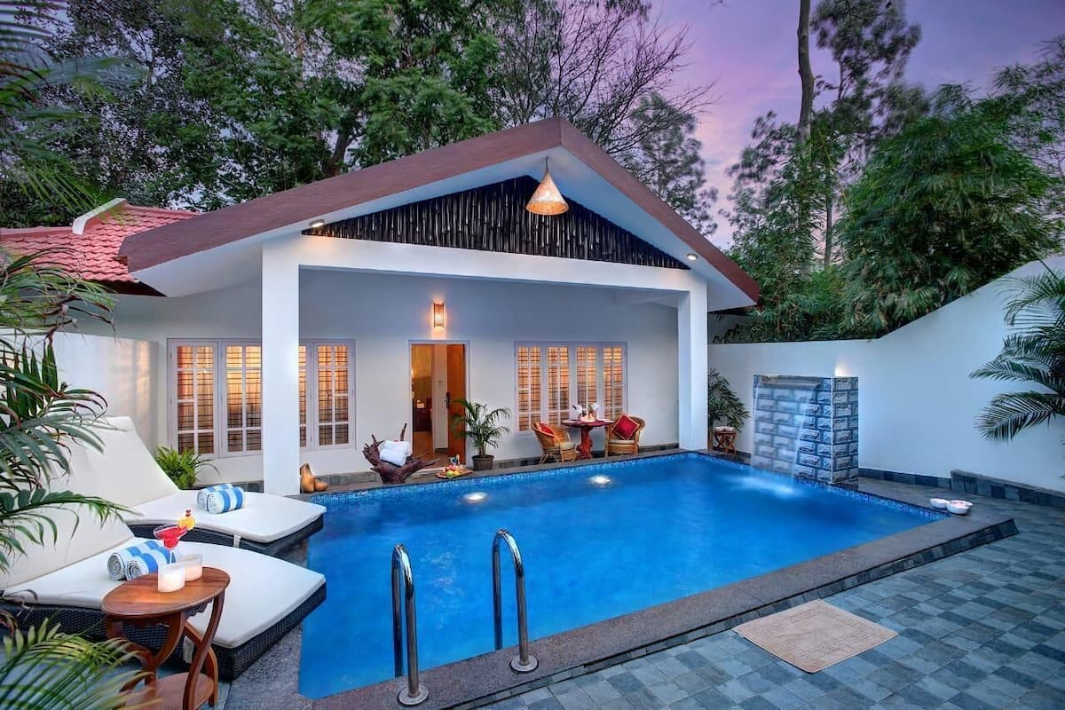 Uma casa moderna com piscina, área de estar externa e uma cascata.