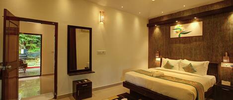 A modern bedroom with a large bed, a nightstand, a mirror, and a door leading to a balcony.