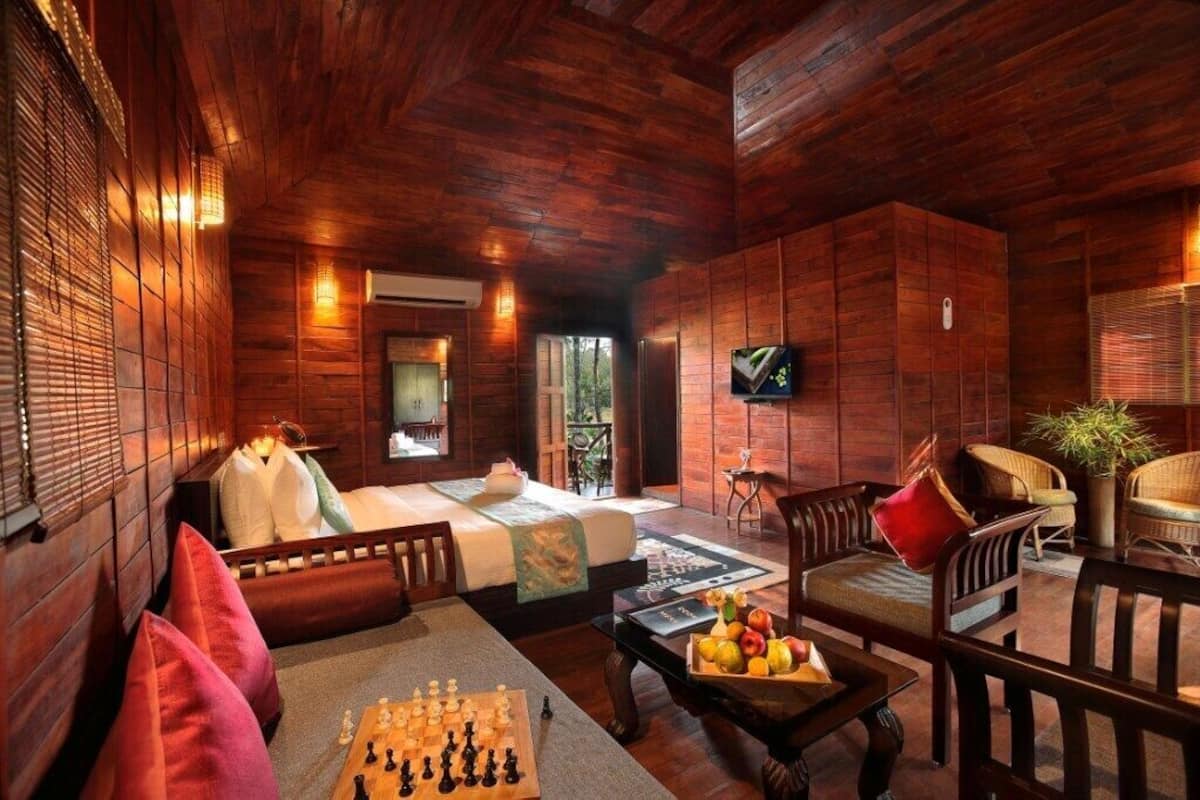 Um quarto acolhedor de madeira com uma cama, área de estar e um tabuleiro de xadrez.