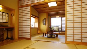Een traditionele Japanse kamer met tatami vloerbedekking, een lage tafel en schuifdeuren.