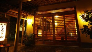 Een traditioneel Japans gebouw met een houten ingang en een lantaarn met Japanse tekens.