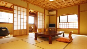 Een traditionele Japanse kamer met tatami vloerbedekking, een lage houten tafel en schuifdeuren.