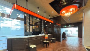 A modern interior with a reception desk, seating area, and a large window. - APA Hotel Okhotsk Kitami (Kitami)