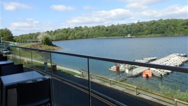 Blick vom Balkon auf einen Fluss mit einem Steg und Booten.