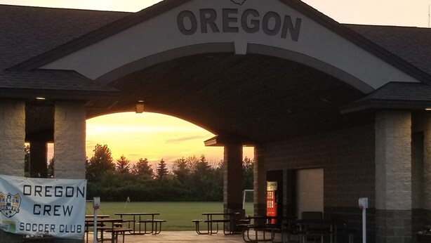 Un edificio con un letrero que dice "OREGON" y otro letrero para el "OREGON CREW SOCCER CLUB".