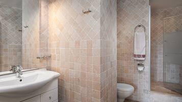 A bathroom with a sink, toilet, and shower.
