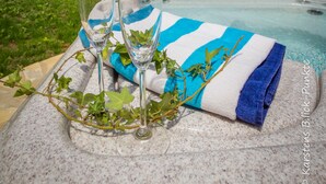 A poolside setting with a table set for two, featuring a towel and two glasses. - Luxury Villa Inge 400 Beach large garden, private pool, air conditioning, BBQ, terrace, WLAN, whirlpool (Els Poblets, Alicante)