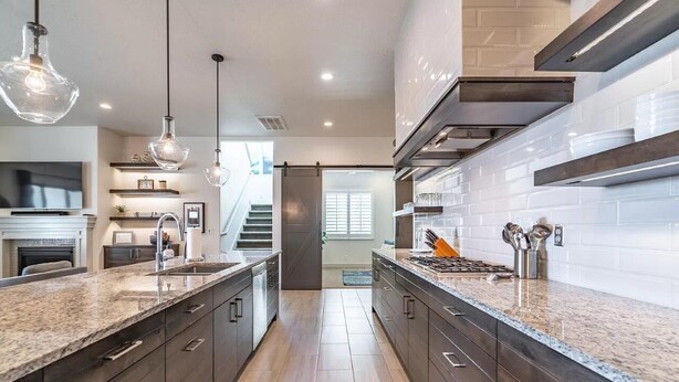 A modern kitchen with granite countertops, dark cabinetry, stainless steel appliances, and pendant lighting. - Arcadia 37 | Fire Pit * Luxury Vacation Villa * Sleeps 18 * Balcony Views (Santa Clara)