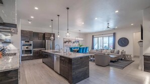 A modern kitchen with dark cabinetry, stainless steel appliances, and pendant lighting. - Arcadia 37 | Fire Pit * Luxury Vacation Villa * Sleeps 18 * Balcony Views (Santa Clara)