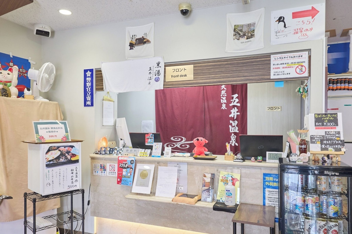 A reception desk with a red curtain, a mirror, and various signs and notices.