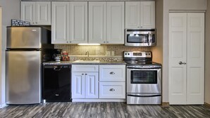 A kitchen with white cabinets, stainless steel appliances, a microwave, and a dishwasher.