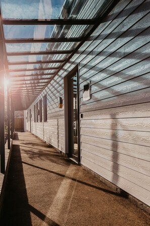 A covered walkway with a patterned wall and a door. - Crown Lodge Hotel (Wisbech)