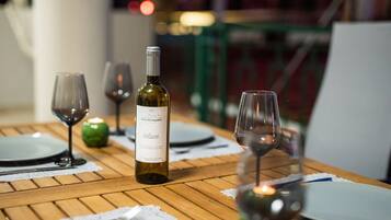 Una mesa puesta con platos, cubiertos, copas de vino y una botella.