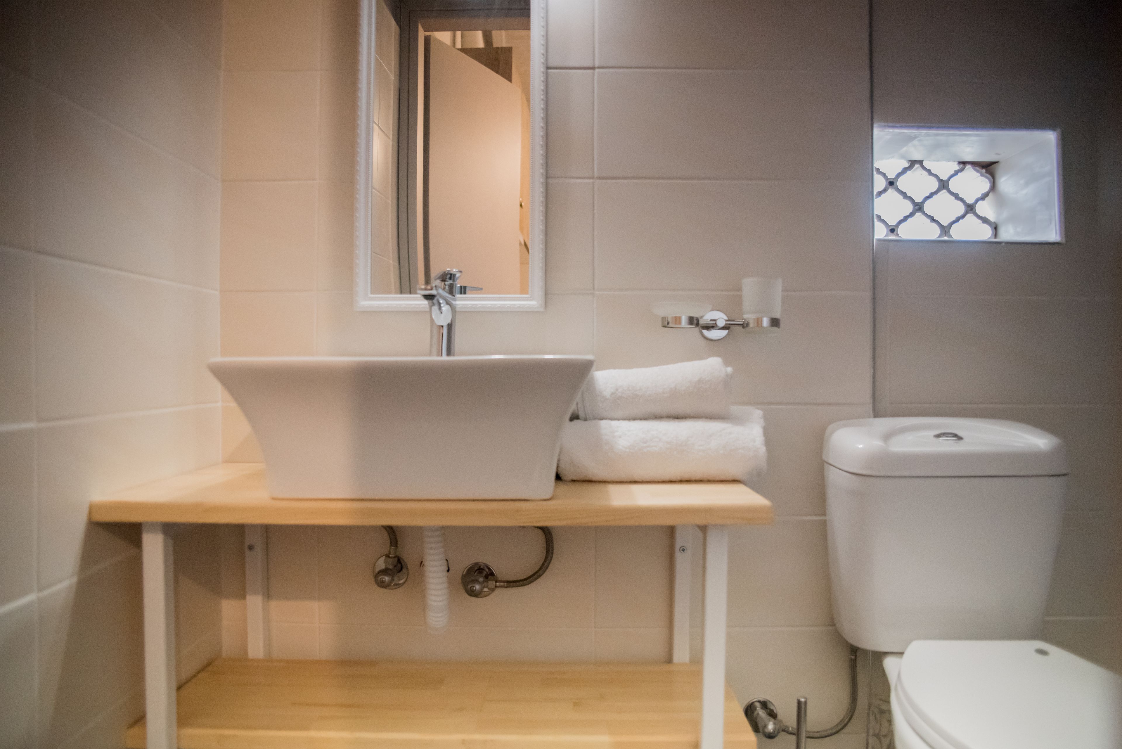 Ein Badezimmer mit Waschbecken, Spiegel, Toilette und Handtuchhalter.