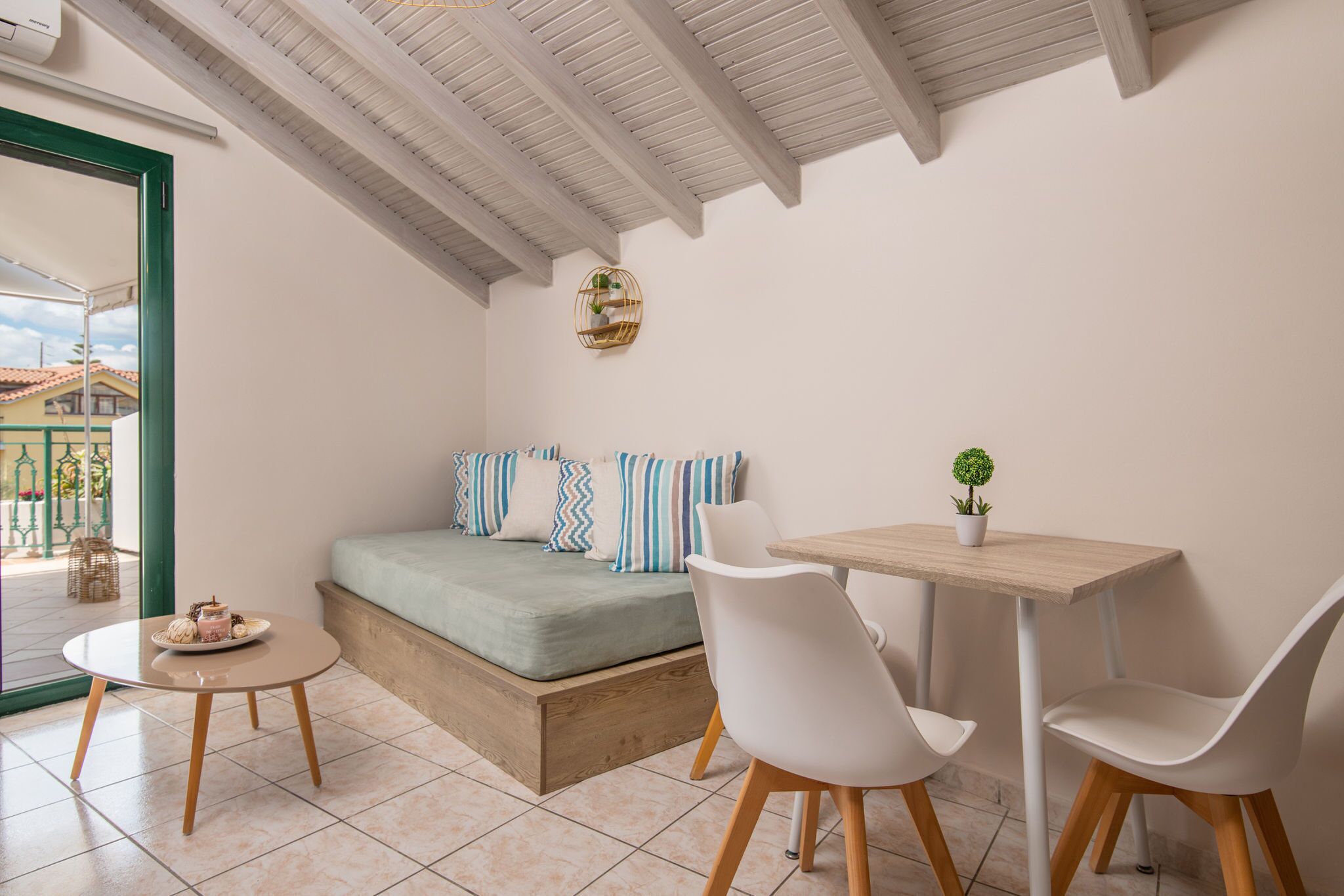 A cozy bedroom with a bed, a small round table, and two chairs.