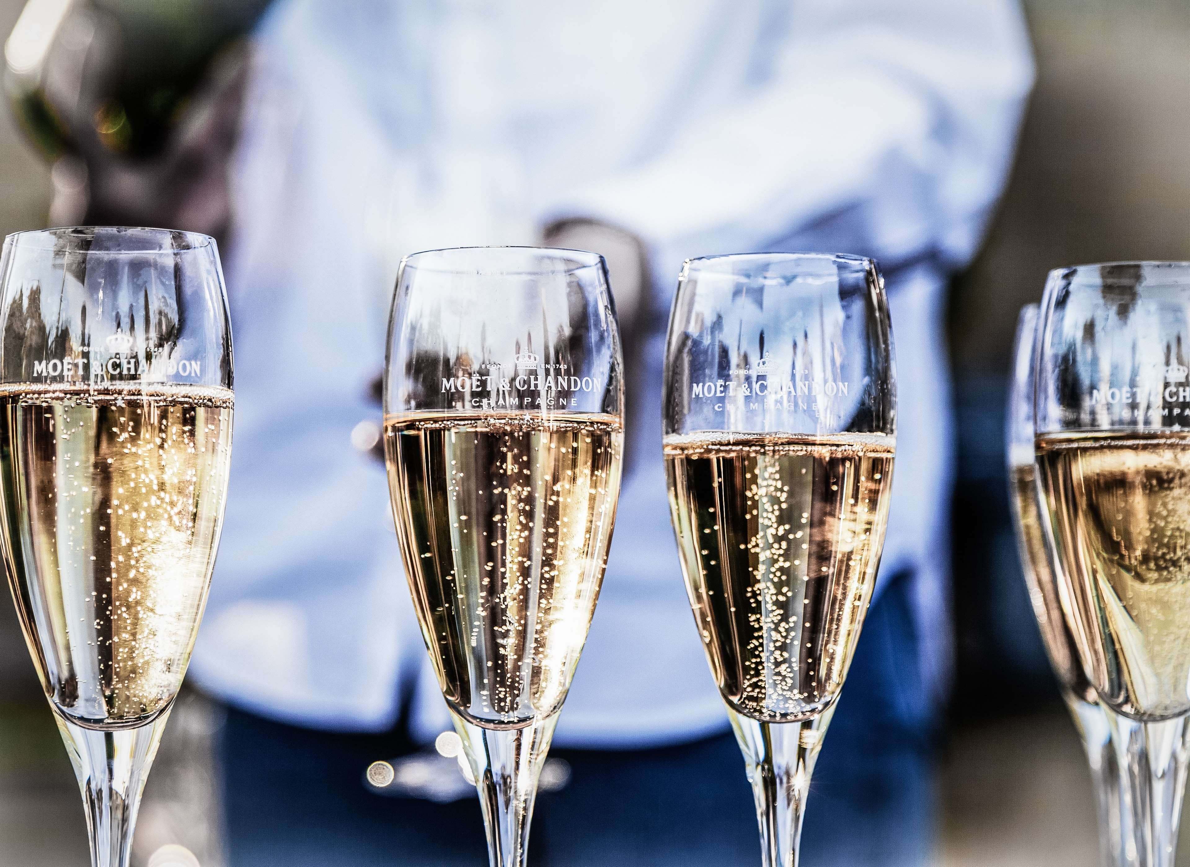 Three champagne glasses with bubbles, placed on a table.