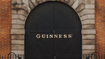 Una puerta arqueada negra con la palabra "GUINNESS" en letras doradas.