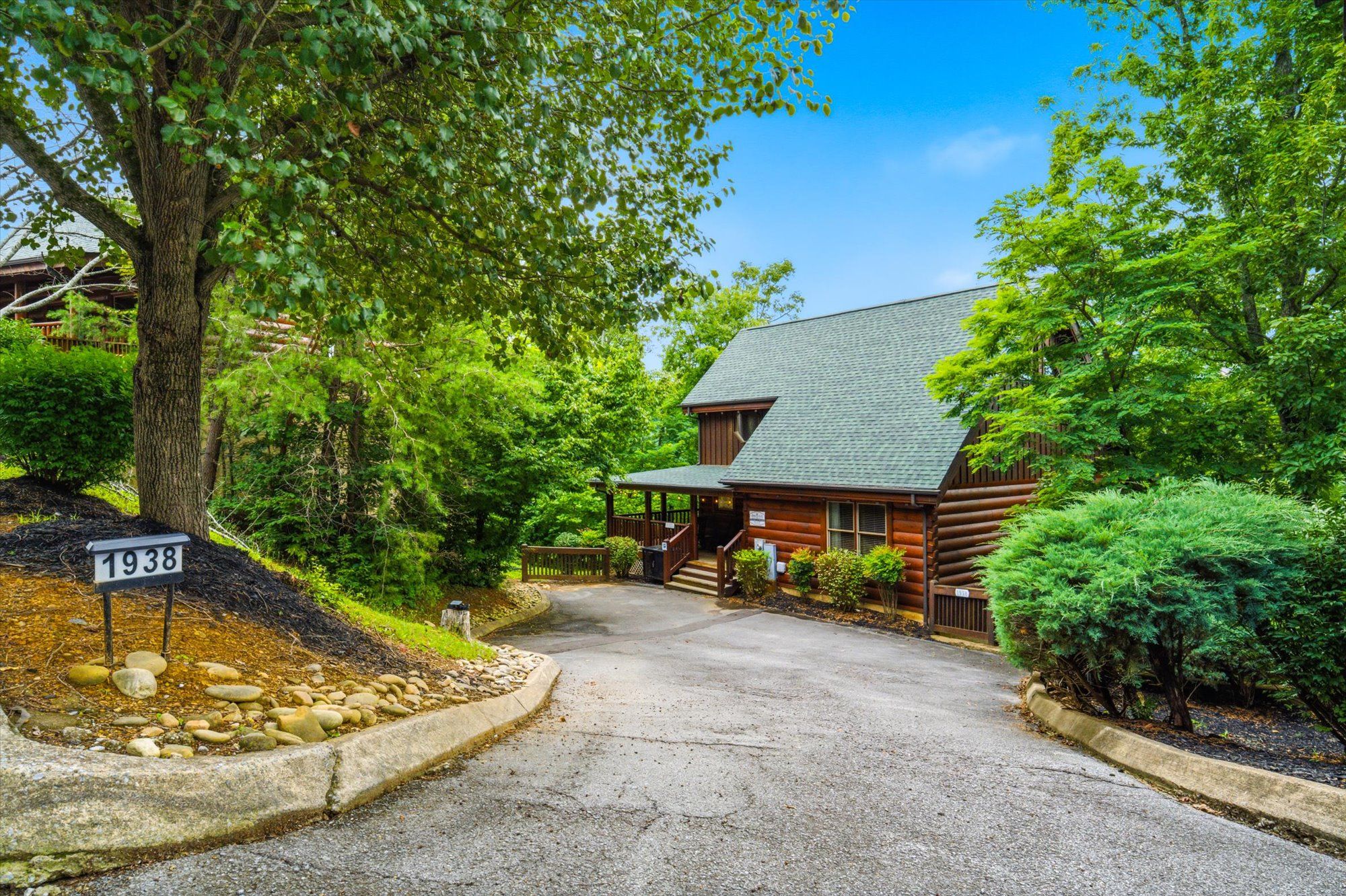 A rustic log cabin with a stone pathway leading to the entrance.
