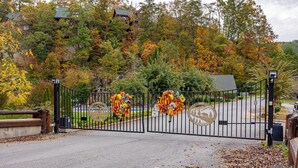 A gated entrance with autumn foliage and decorative wreaths.