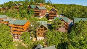Un grupo de cabañas de madera de varios pisos y balcones, rodeadas por un bosque denso.