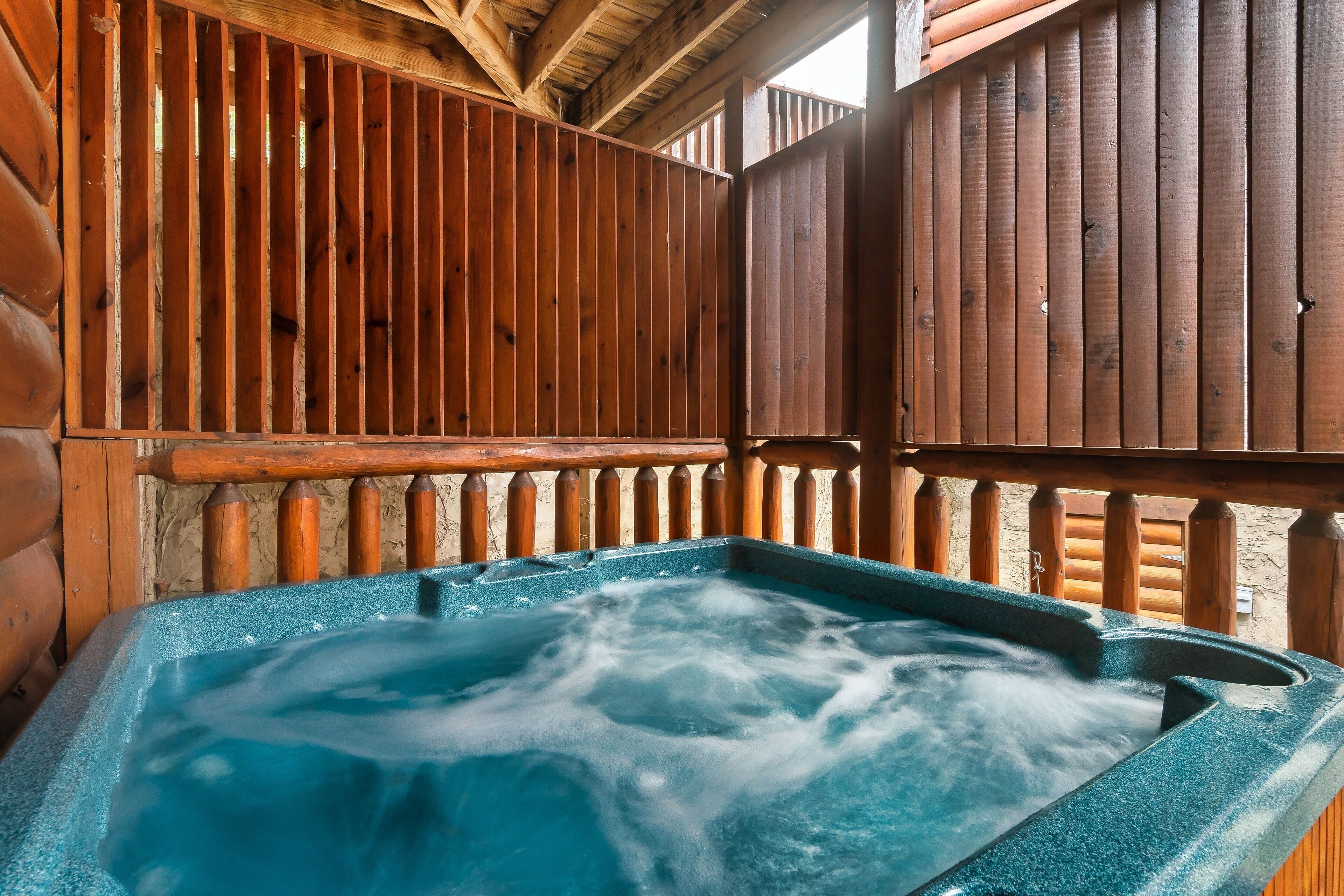 A hot tub with a wooden deck and railings.