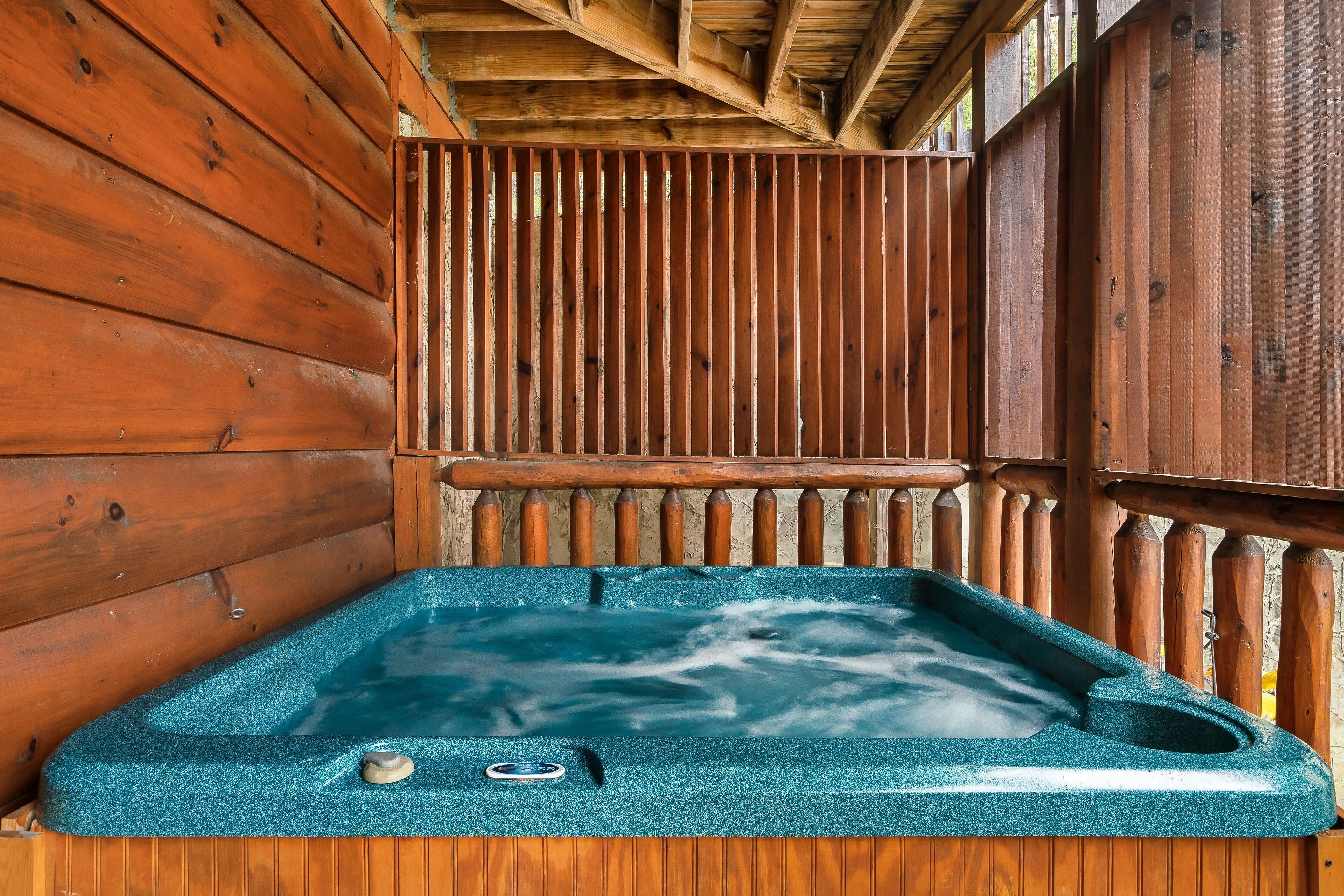 Una vasca idromassaggio con un'area prendisole in legno e pareti in legno.