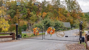 A gated entrance with autumn foliage and decorative wreaths.