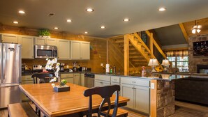 A modern kitchen with wooden cabinetry, stainless steel appliances, and a central island.