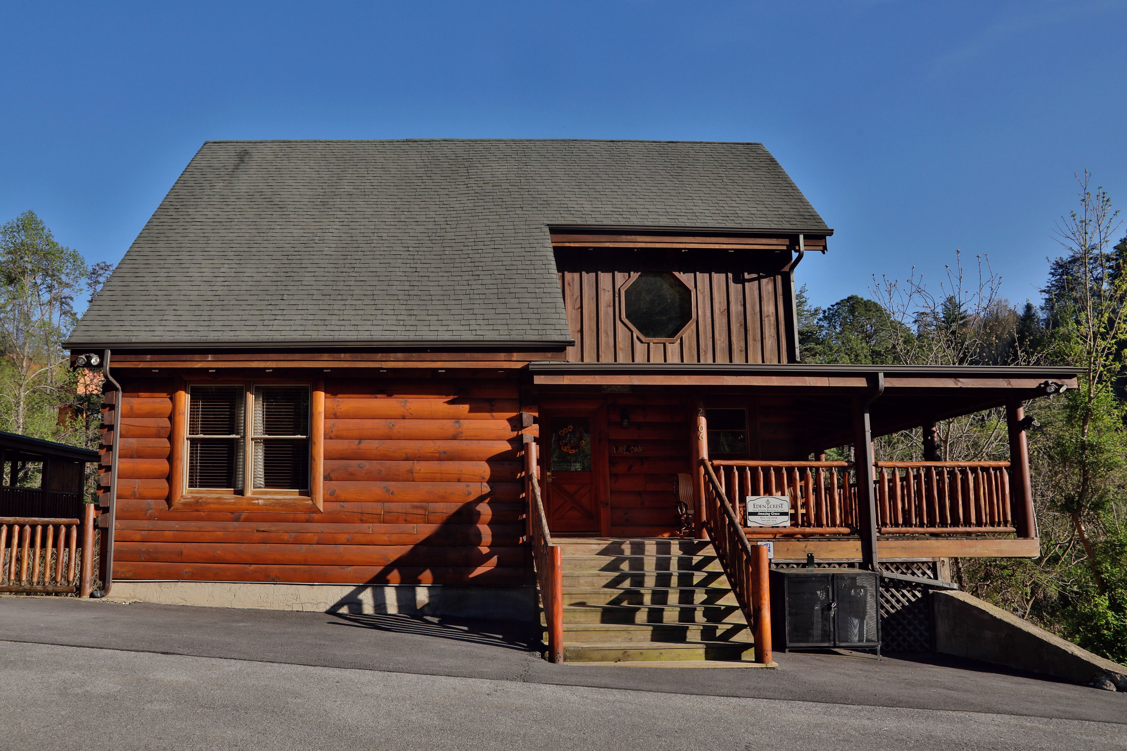 A wooden cabin with a porch and a staircase leading to the entrance.