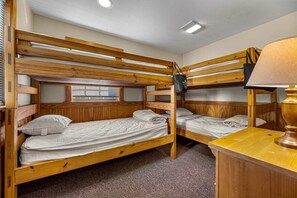 A room with two bunk beds, a wooden desk, and a lamp. - Poplar Point Condo Unit 12A - Two Bedroom Condo (Pigeon Forge)