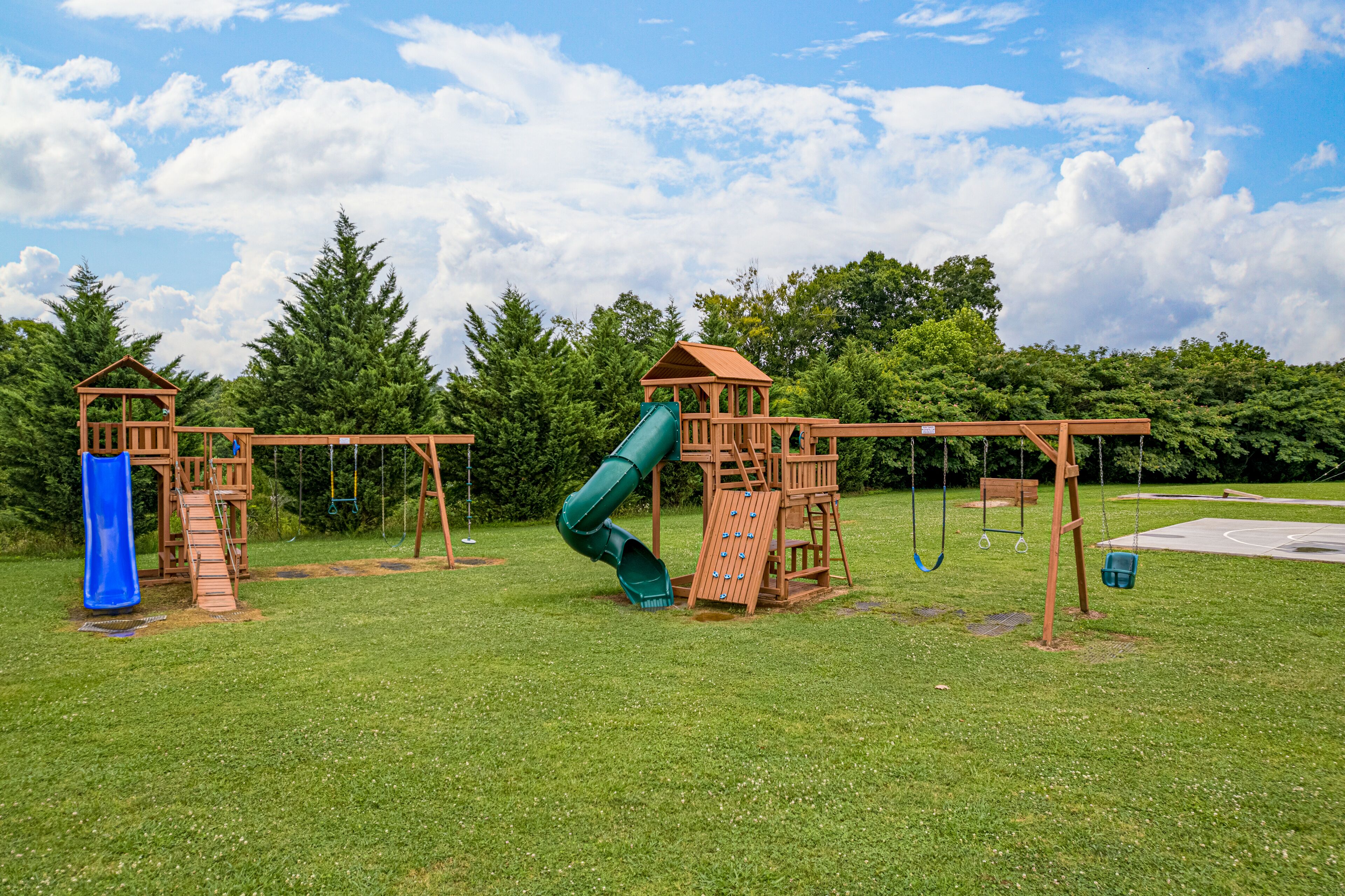 A playground with two slides and swings.