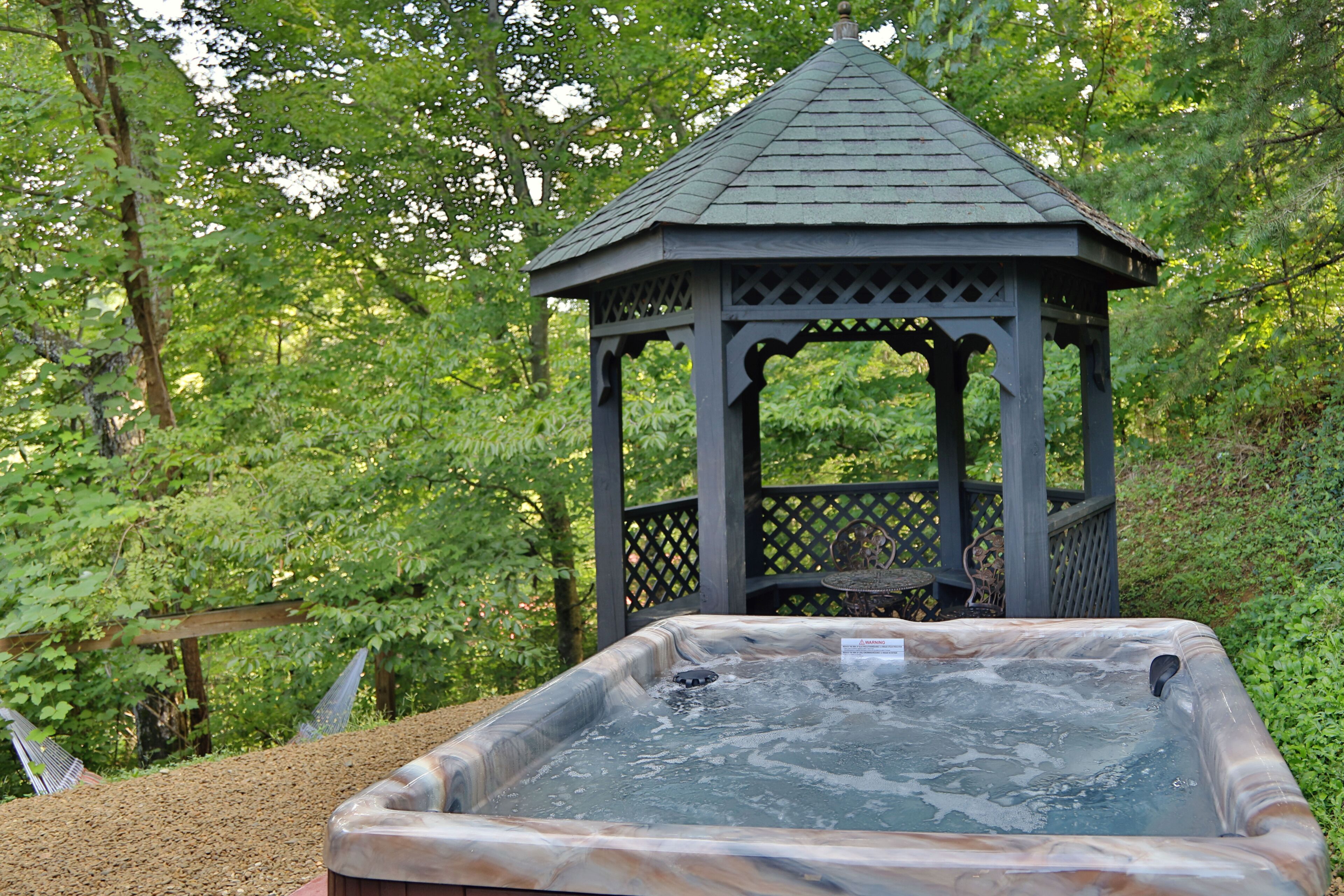 Un mirador con jacuzzi en un área boscosa.