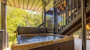 A hot tub labeled "UNIT 13F" with a wooden exterior and a view of trees in the background. - Briarstone Lodge Condo 13F - Three Bedroom Condo (Pigeon Forge)