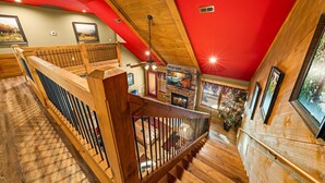 Eine Holztreppe mit roter Decke und Kamin.
