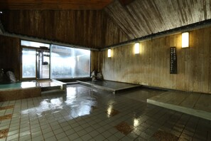A traditional Japanese onsen with wooden interiors and tiled floors. - Tabinoyado Asonoyu (Aso)
