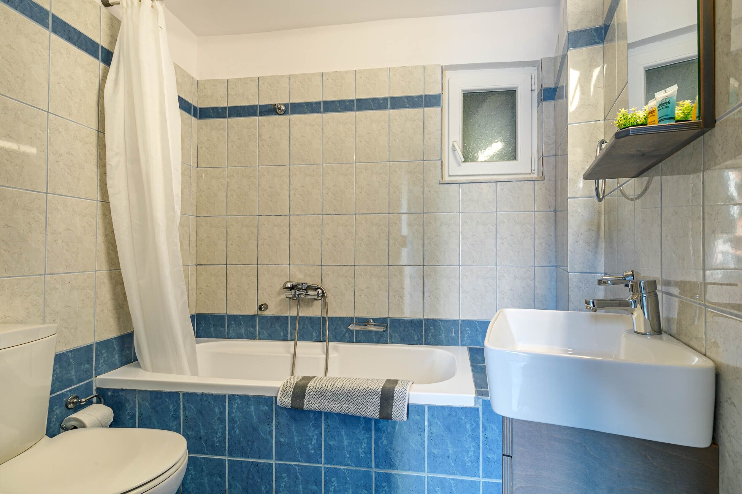 A bathroom with a bathtub, a sink, and a toilet.