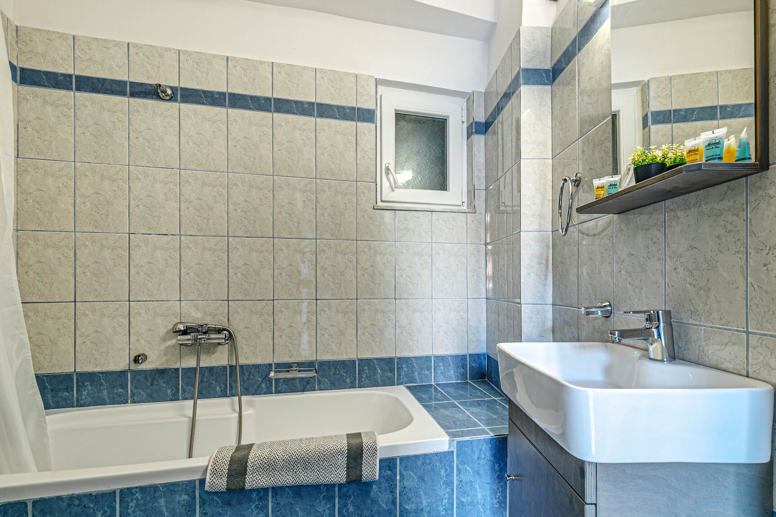 Ein modernes Badezimmer mit Badewanne, Dusche und Waschbecken.