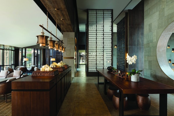 A modern hotel lobby with a central bar, seating area, and a decorative wall. - JW Marriott Hotel Qufu (Jining)