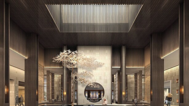 Un'ampia hall con un albero centrale, una zona salotto circolare e un design architettonico moderno.