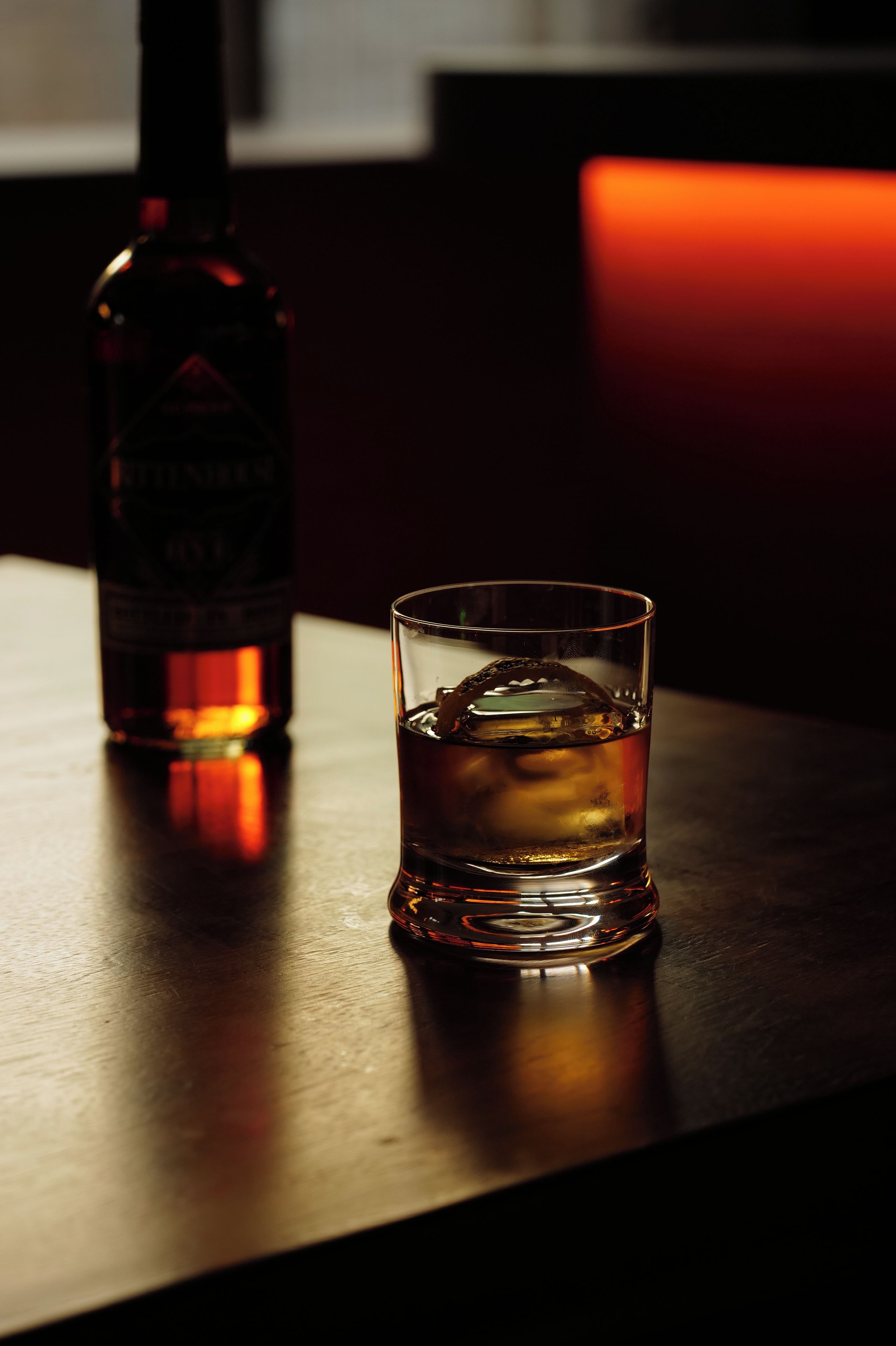 Un verre de whisky et une bouteille sur une table.